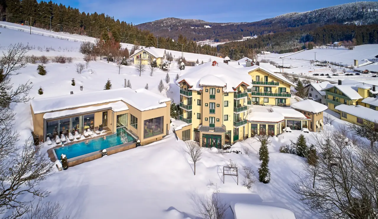 Winterliche Aussenansicht des Hotel Reinerhof **** mit beheiztem Aussenpool und verschneiter Berglandschaft.