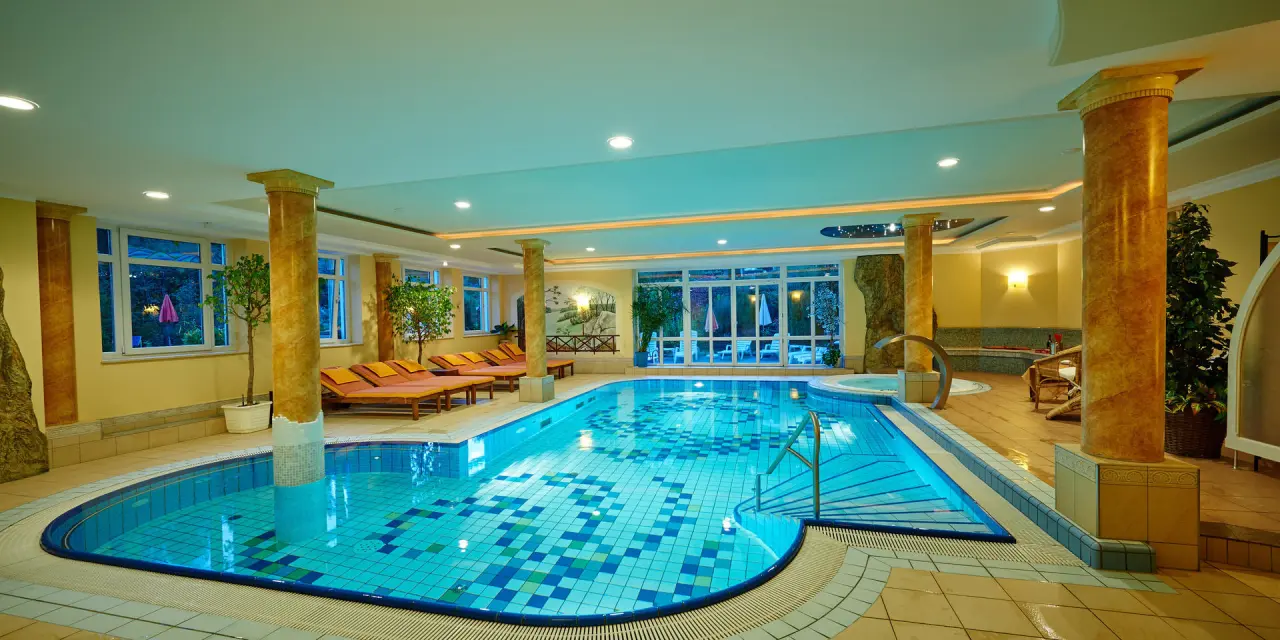 Grosszügiger Innenpool mit Mosaikfliesen, Whirlpool und Liegebereich im Wellnessbereich des Hotel Brunnenhof.