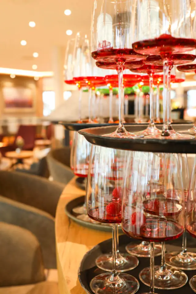 Gestapelte Weingläser mit roten Getränken und Himbeeren im Restaurantbereich des Hotel Laschenskyhof.