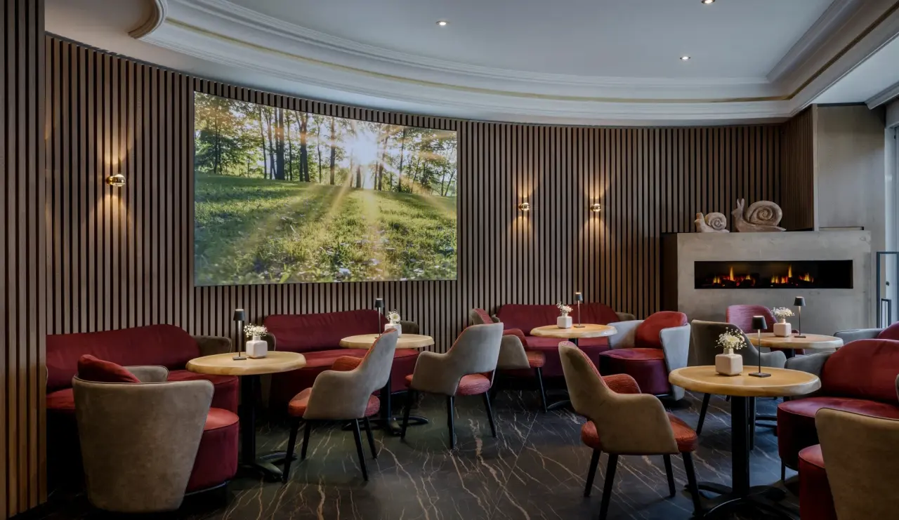 Gemütliche Lounge im Hotel Lamm mit bequemen Sitzgelegenheiten, Kamin und Natur-Projektion für entspannte Stunden.