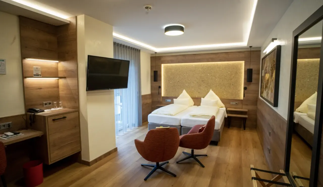 Modernes Doppelzimmer im Hotel Lamm mit Holzelementen, gemütlichen Sesseln und indirekter Beleuchtung.