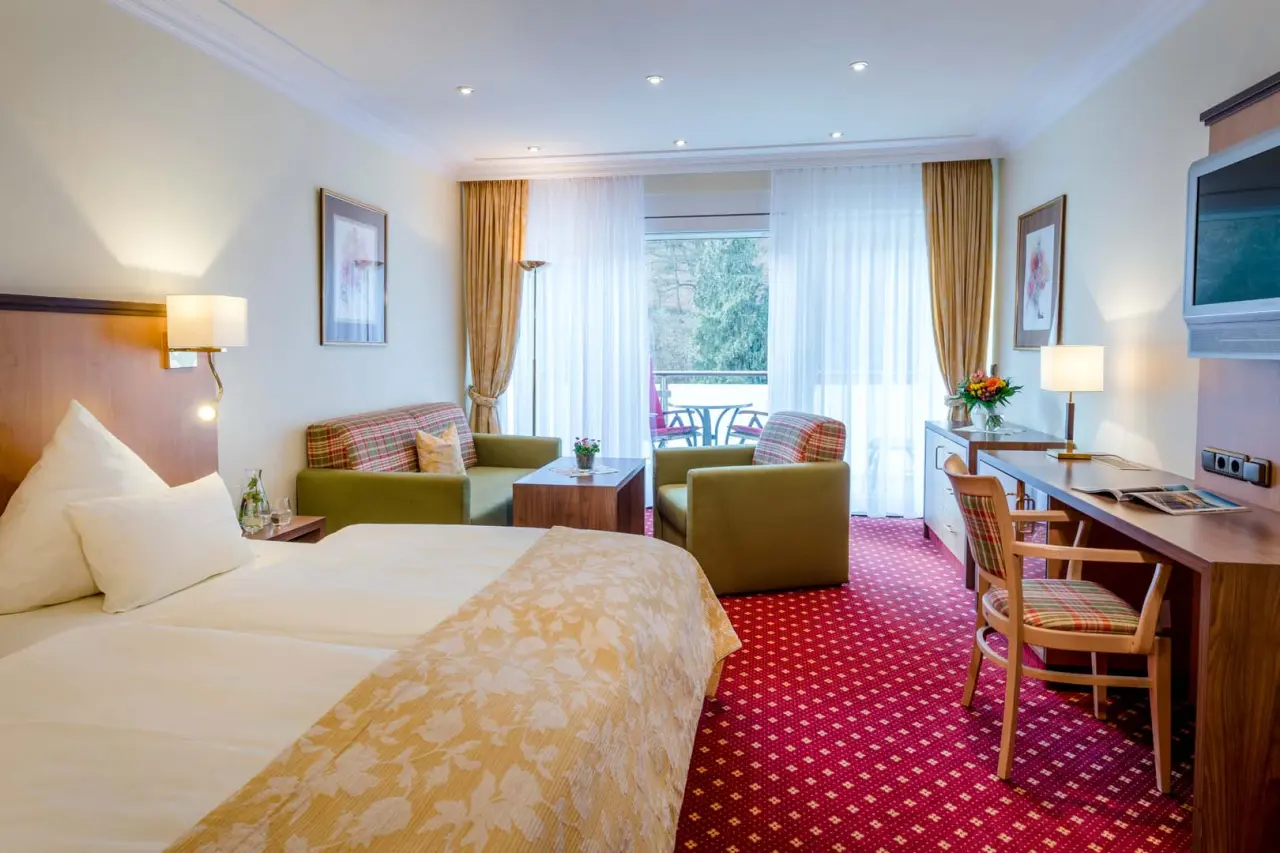 Gemütliches Doppelzimmer im Hotel Lamm mit Balkon, Sitzbereich und Schreibtisch.