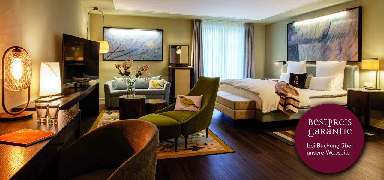 Geräumiges und stilvolles Hotelzimmer im Hotel Erbprinz mit Doppelbett, Sitzbereich und Schreibtisch.