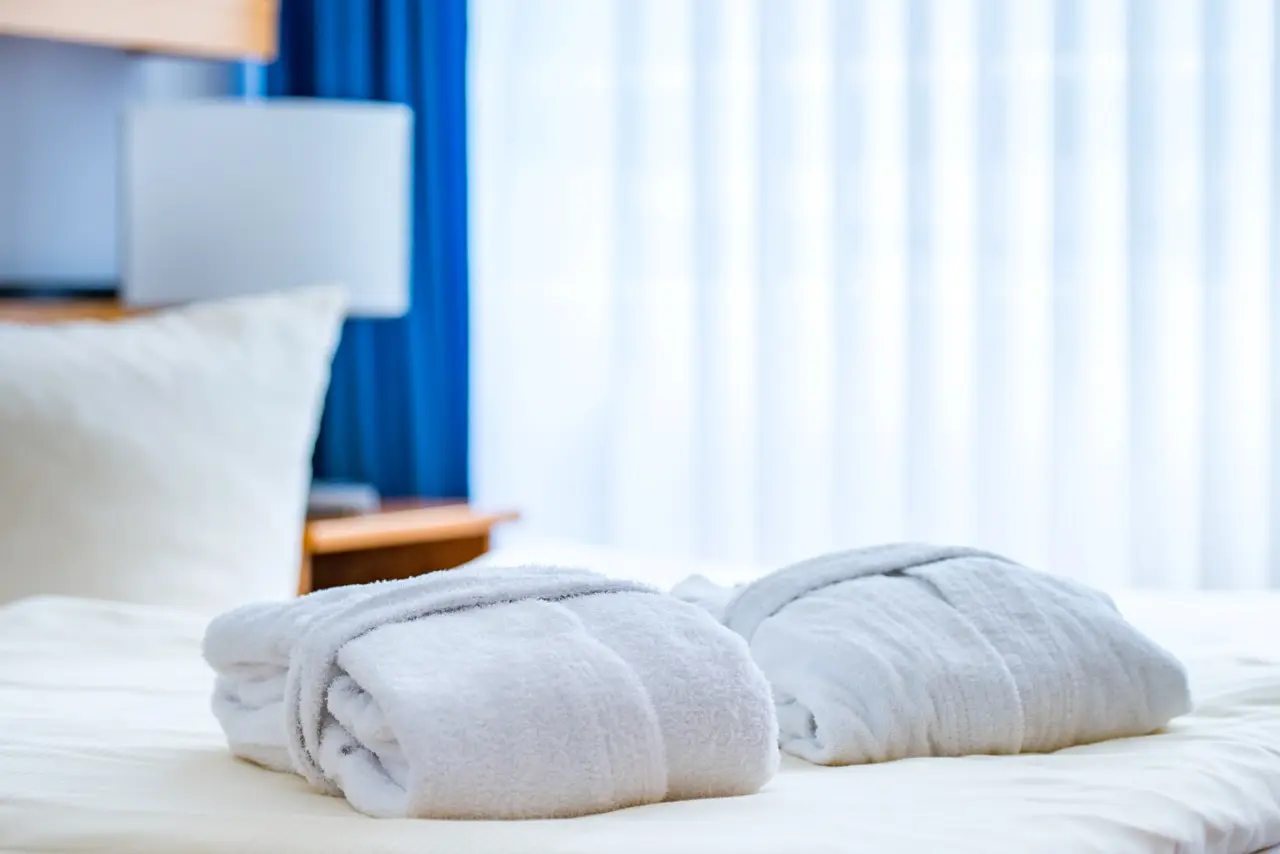 Zwei weiche Bademäntel auf dem Bett im Hotelzimmer des Hotel an der Therme Bad Sulza, bereit für den Wellnessbereich.