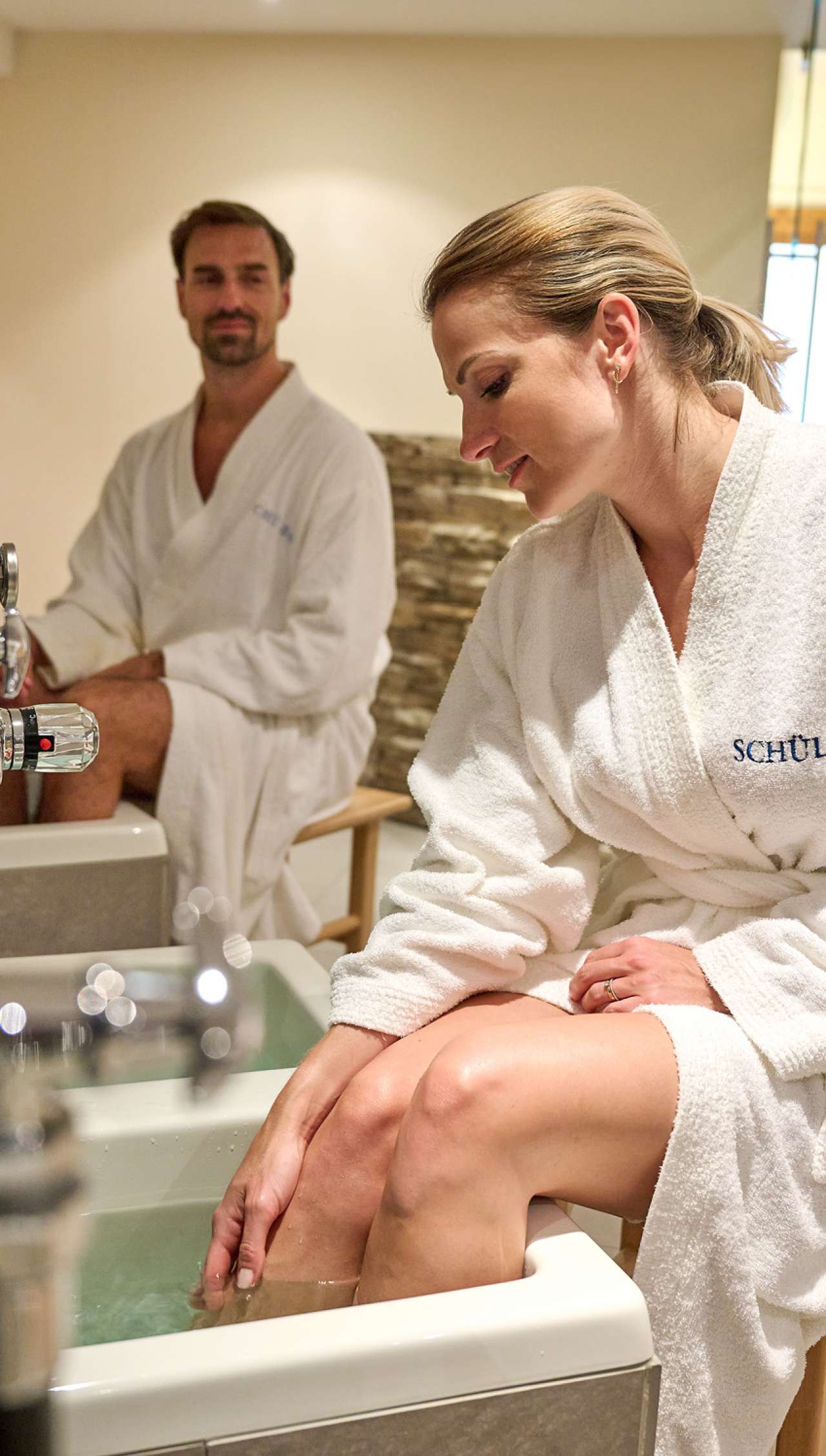 SCHÜLE'S Gesundheitsresort & Spa in Oberstdorf – Paar genießt ein entspannendes Fußbad | Wellnesshotel Allgäu