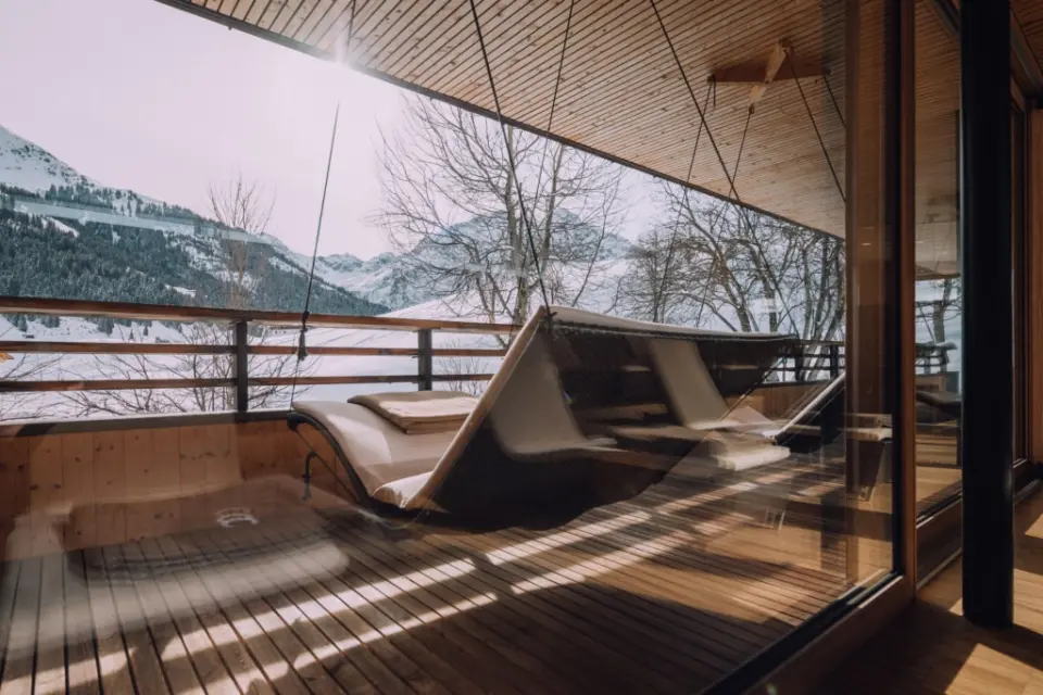 Entspannungsbereich mit Liegen und Panoramablick auf die verschneiten Berge im Naturhotel Chesa Valisa****s.