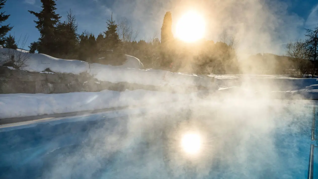 Beheizter Aussenpool mit Dampf und Schnee im Winter im Hotel Dein Engel. Idyllische Wellness-Oase.