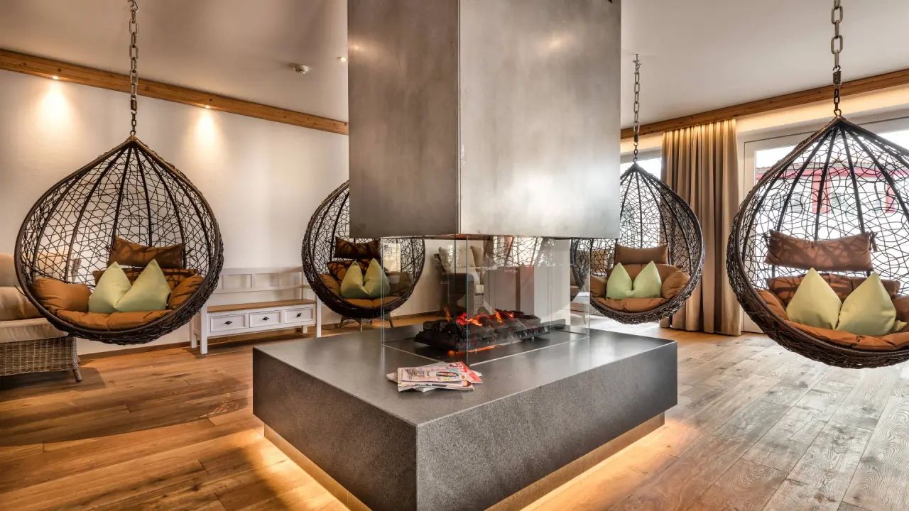 Einladender Spa-Loungebereich mit modernen Hängesesseln und Kamin im Hotel Dein Engel.