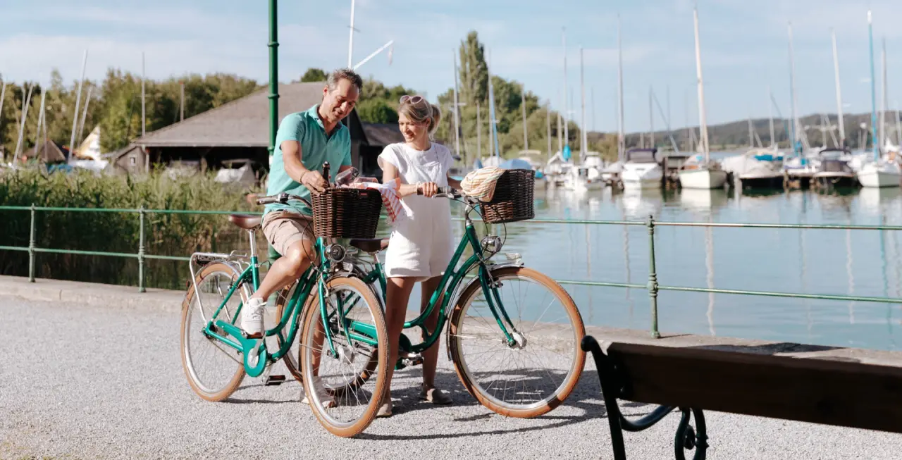 Paar mit Fahrrädern und Picknickkorb am Mattsee. Aktive Erholung im Seewirt Mattsee Kuschelhotel & Spa.