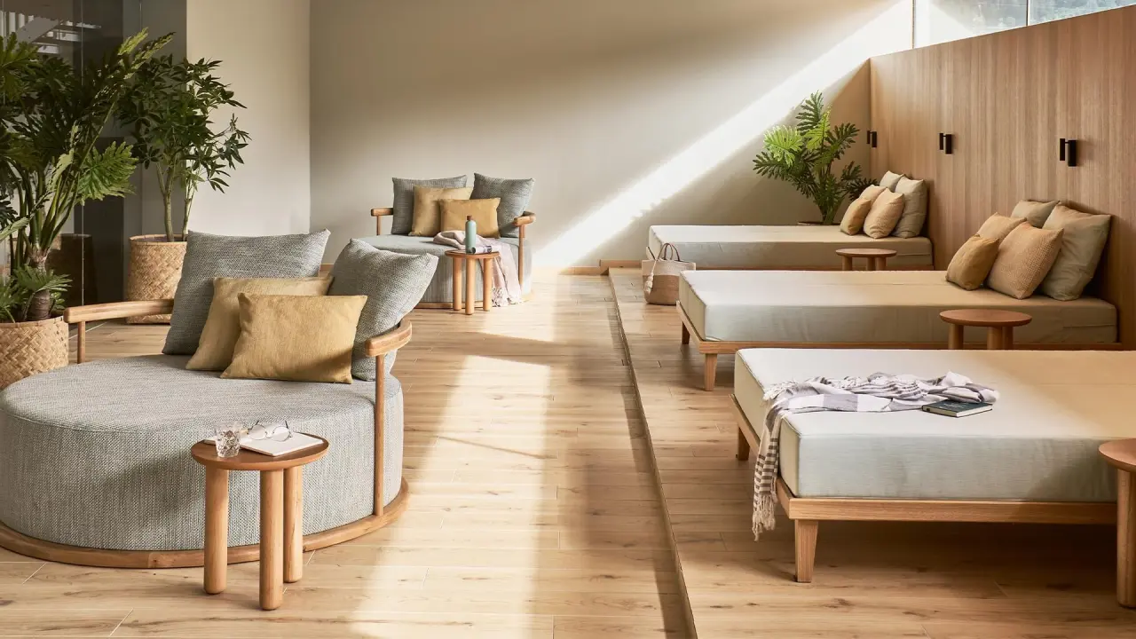 Entspannungsbereich mit bequemen Liegen und Sesseln im Spa des Falkensteiner Carinzia Hotels, mit natürlichem Licht und Pflanzen.