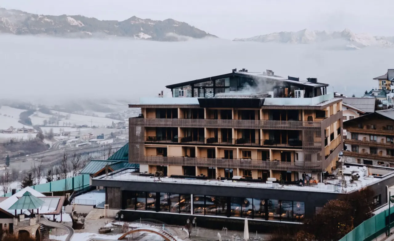 Hotel Berghof in St. Johann in Salzburg im Winter mit verschneiter Landschaft und Bergblick.