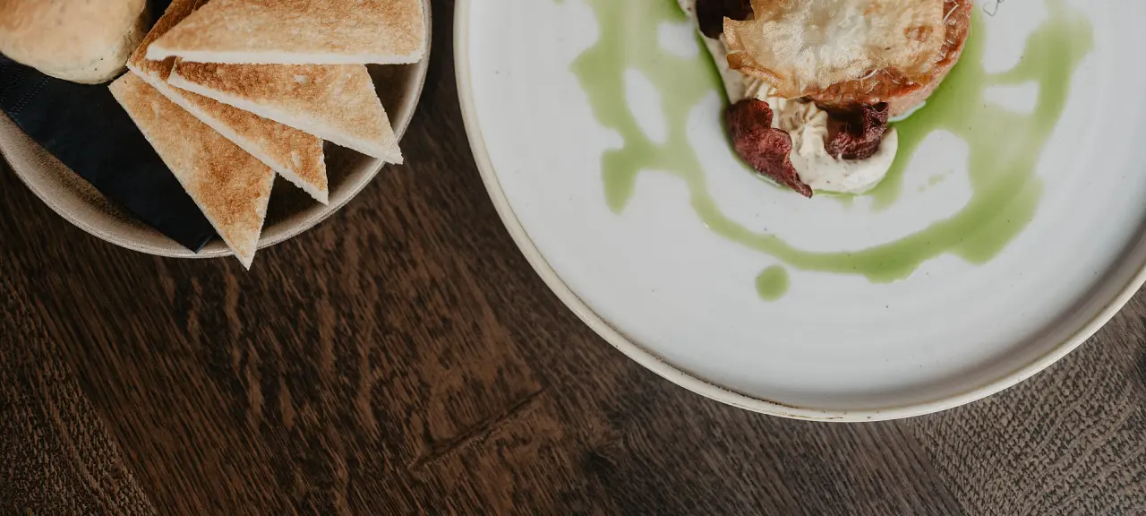 Kreativ angerichtete Vorspeise mit Toast und Kräutersauce im Restaurant des Hotel Berghof in St. Johann in Salzburg.