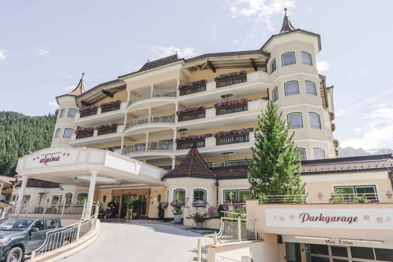 Traumhotel Alpina Adults Only Hotel Yoga Ayurveda: Elegante Aussenansicht mit blühenden Balkonen und Bergkulisse.