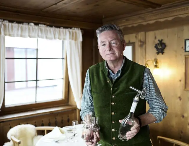 Gastgeber des Sporthotel Steffisalp im traditionellen Restaurant, präsentiert lokale Spirituosen.