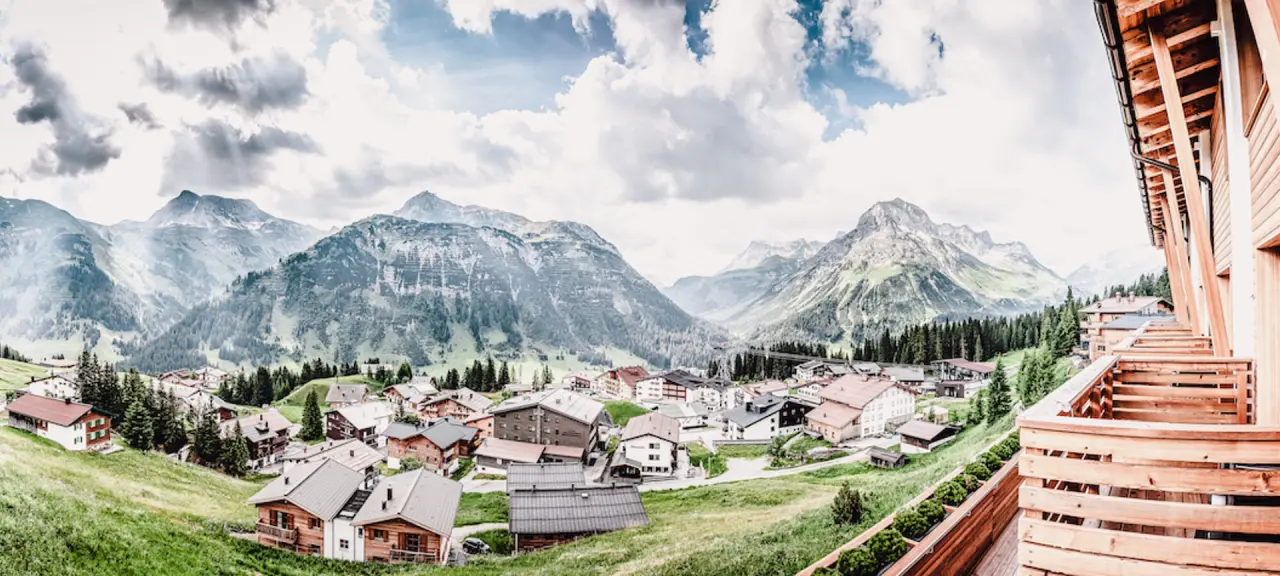 Panoramablick auf das alpine Bergdorf und die majestätischen Alpen vom Hotel Goldener Berg.