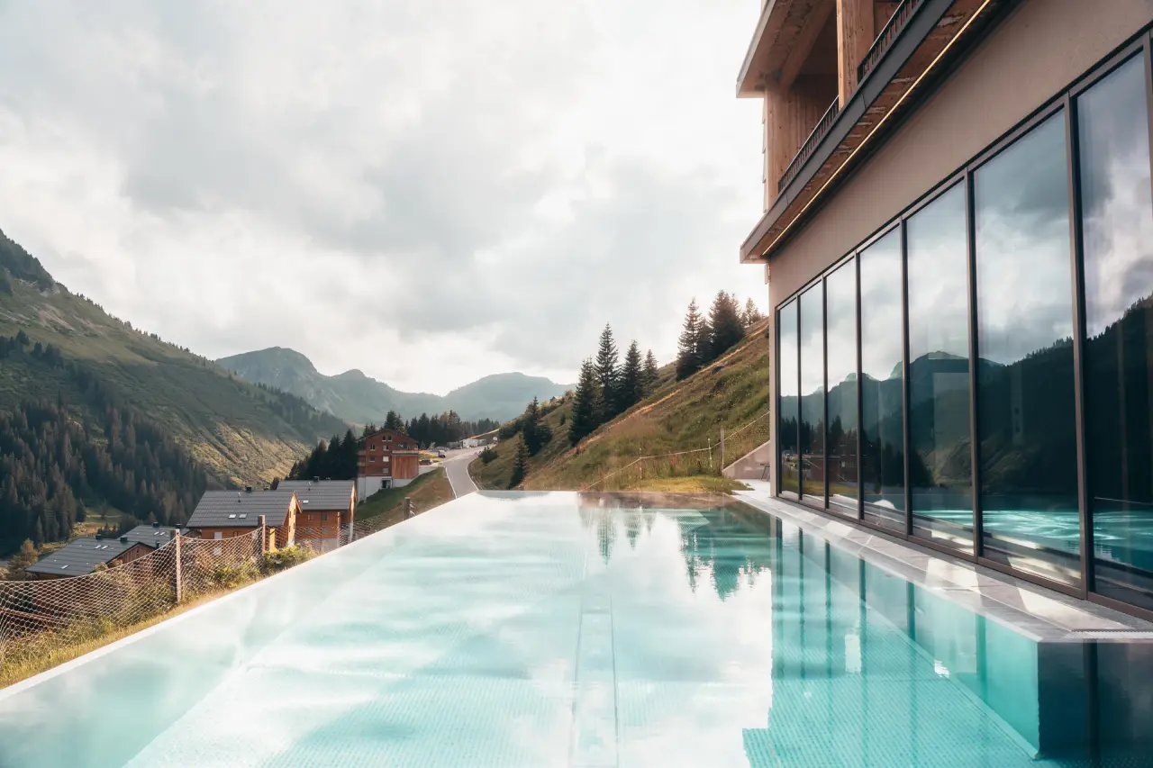 Beheizter Infinity Pool mit atemberaubendem Bergpanorama im Alpenstern Panoramahotel. Perfekt für Wellness und Entspannung in den Alpen.