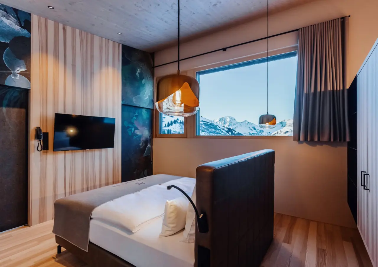 Modernes Hotelzimmer im Alpenstern Panoramahotel mit gemütlichem Bett und atemberaubendem Bergblick.