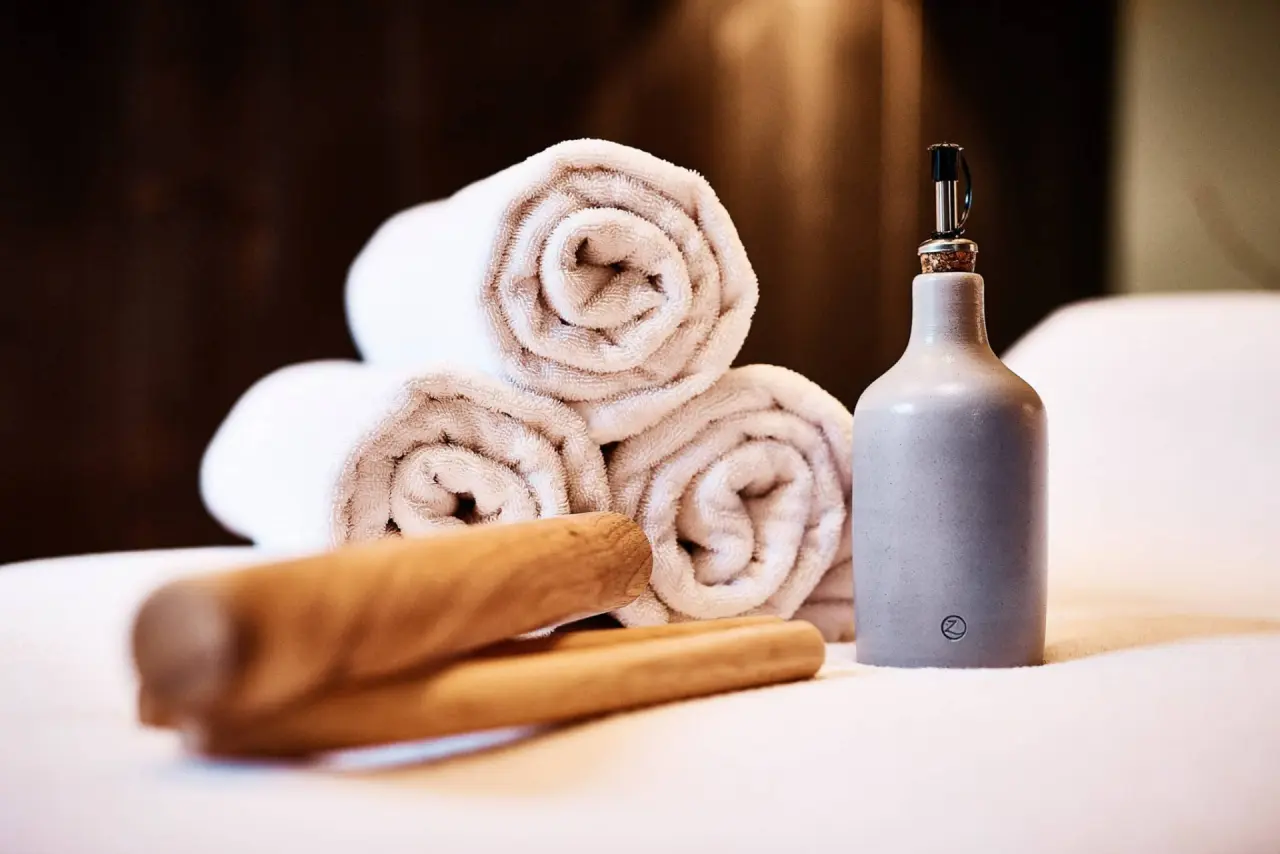 Wellness-Handtücher, Massageöl und Holz-Massagestäbe für entspannende Behandlungen im Hotel Zugbrücke Grenzau.