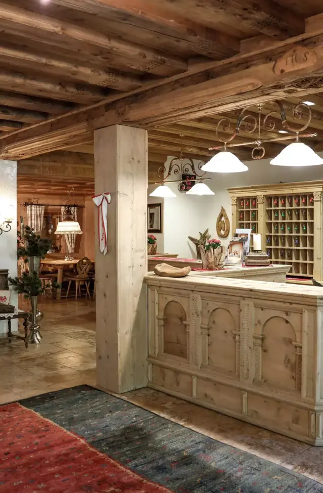 Traditionelle Holzrezeption und gemütlicher Empfangsbereich im Alpenromantik Hotel Wirlerhof.