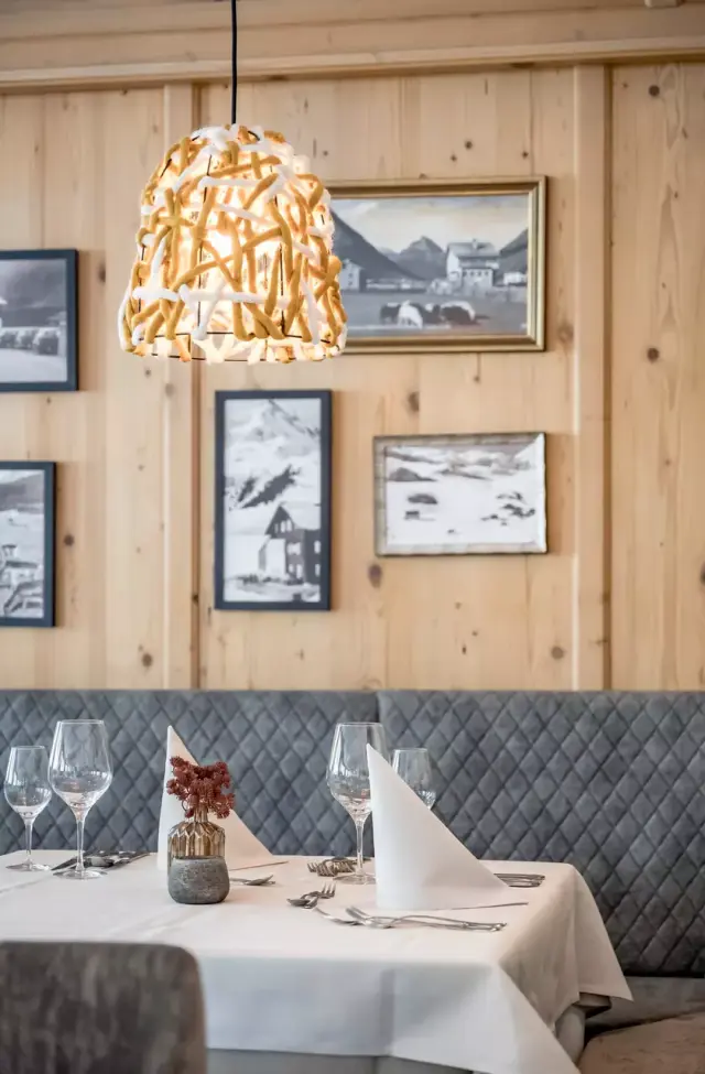 Gemütlicher Restaurantbereich im Alpenromantik Hotel Wirlerhof mit stilvoll gedecktem Tisch und alpiner Einrichtung.