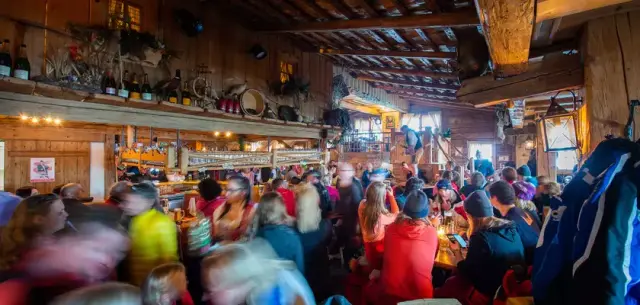 Belebte Après-Ski Bar im Alpenromantik Hotel Wirlerhof mit vielen Gästen und Live-Musik in rustikalem Ambiente.