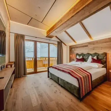 Gemütliches Doppelzimmer im Alpenromantik Hotel Wirlerhof mit Holzelementen, Balkon und Bergblick.
