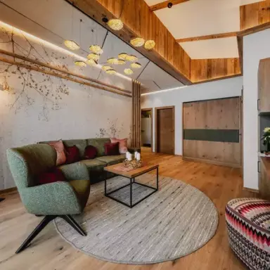 Gemütlicher Wohnbereich einer Suite im Alpenromantik Hotel Wirlerhof mit modernem Alpendesign und Holzelementen.