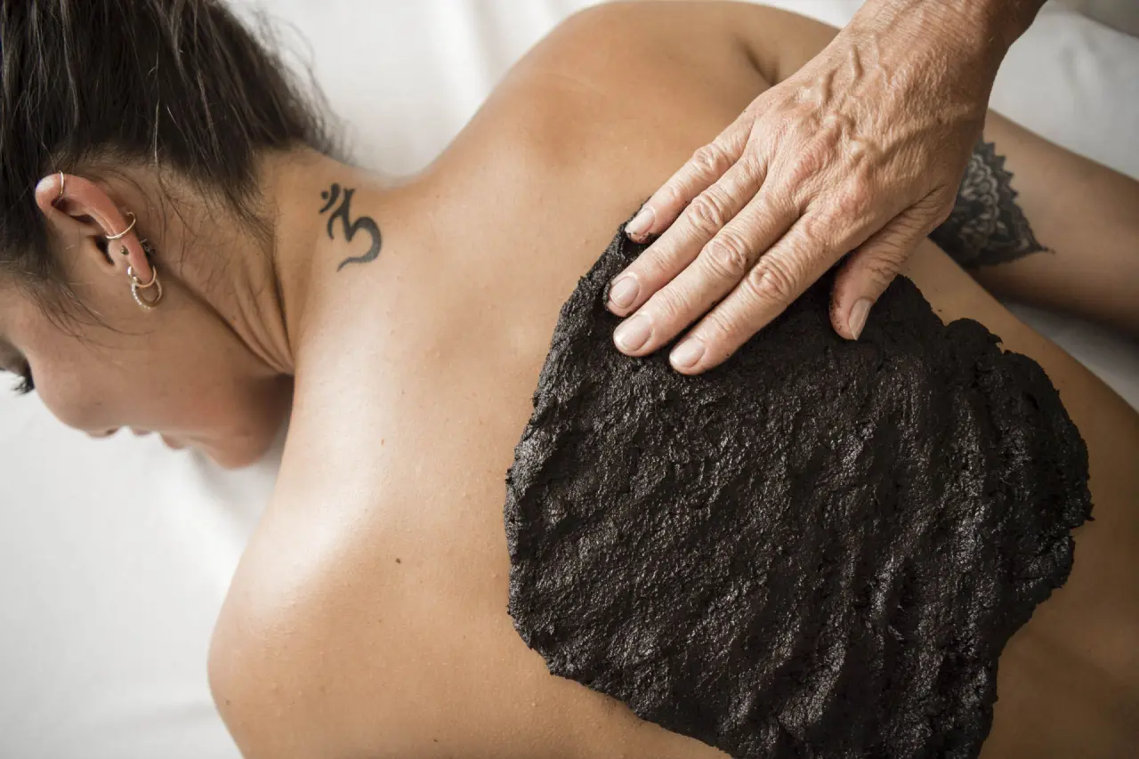 Entspannende Moorpackung auf dem Rücken einer Frau im Wellnessbereich des Parkhotel am Soier See.