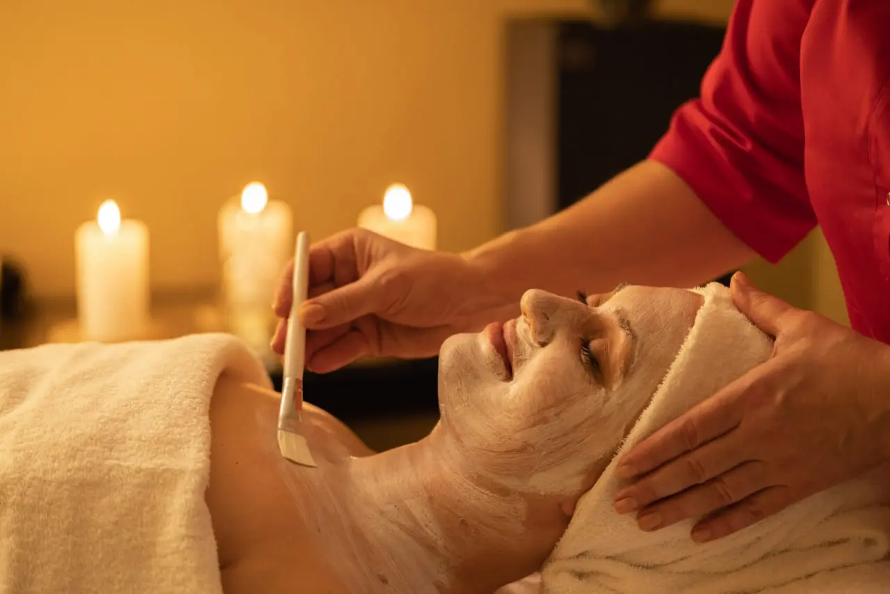 Entspannende Gesichtsbehandlung mit pflegender Maske und warmem Kerzenlicht im Spa des Tanneck Golf & Spa.