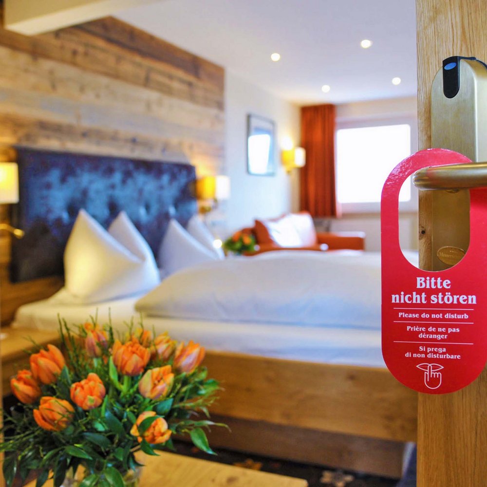 Wellnesshotel Randsbergerhof in Cham – Gemütliches Hotelzimmer mit Blumen und Türschild | Wellnesshotel Bayerischer Wald