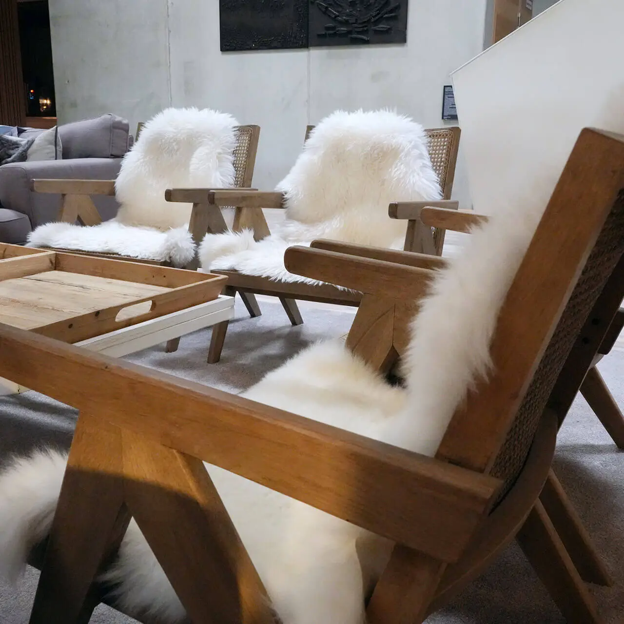 Gemütliche Lounge-Sessel mit Schaffellauflagen und Holztisch im Hotel Tannenhof Sport & SPA.
