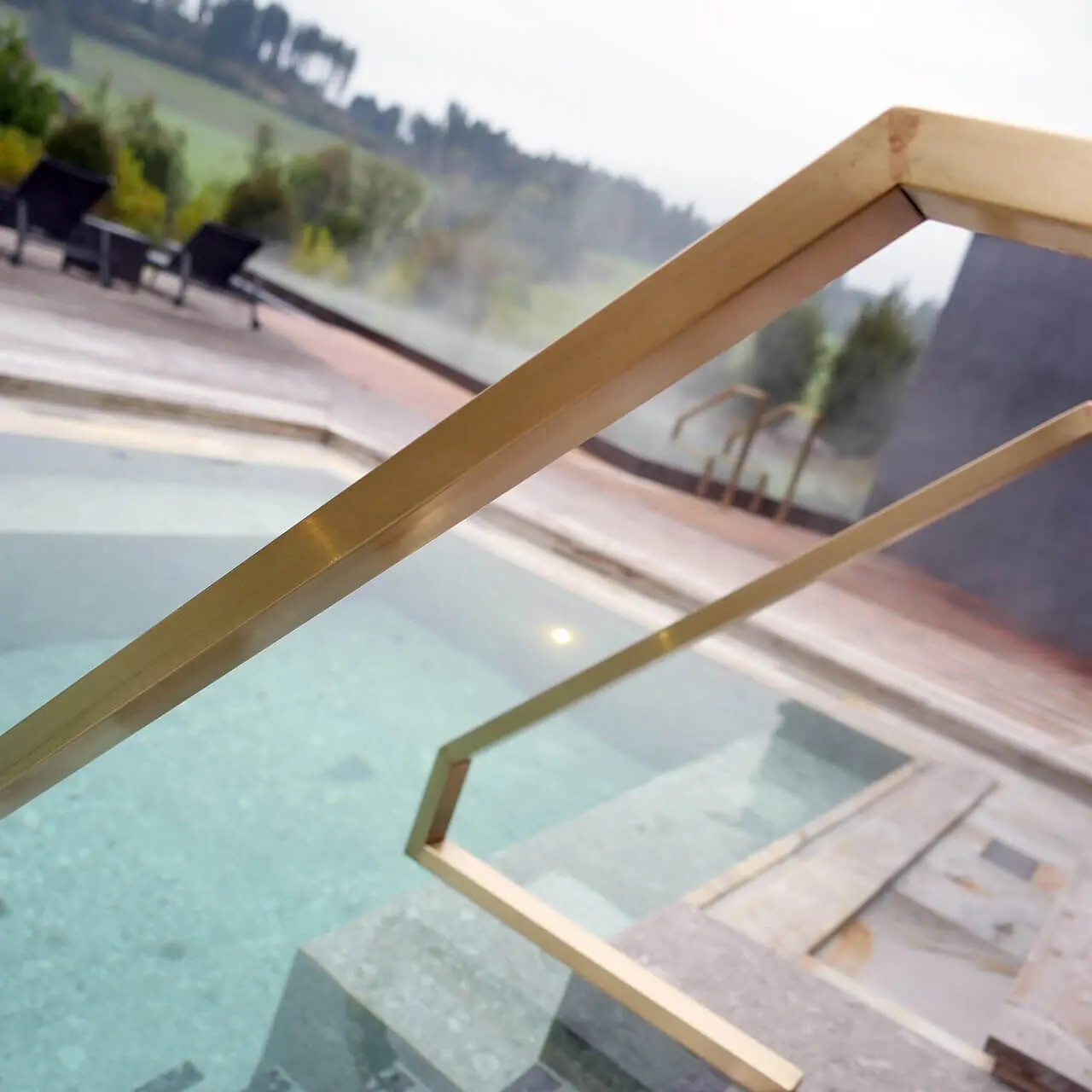 Beheizter Aussenpool mit goldener Treppe und Dampf im Tannenhof Sport & SPA.