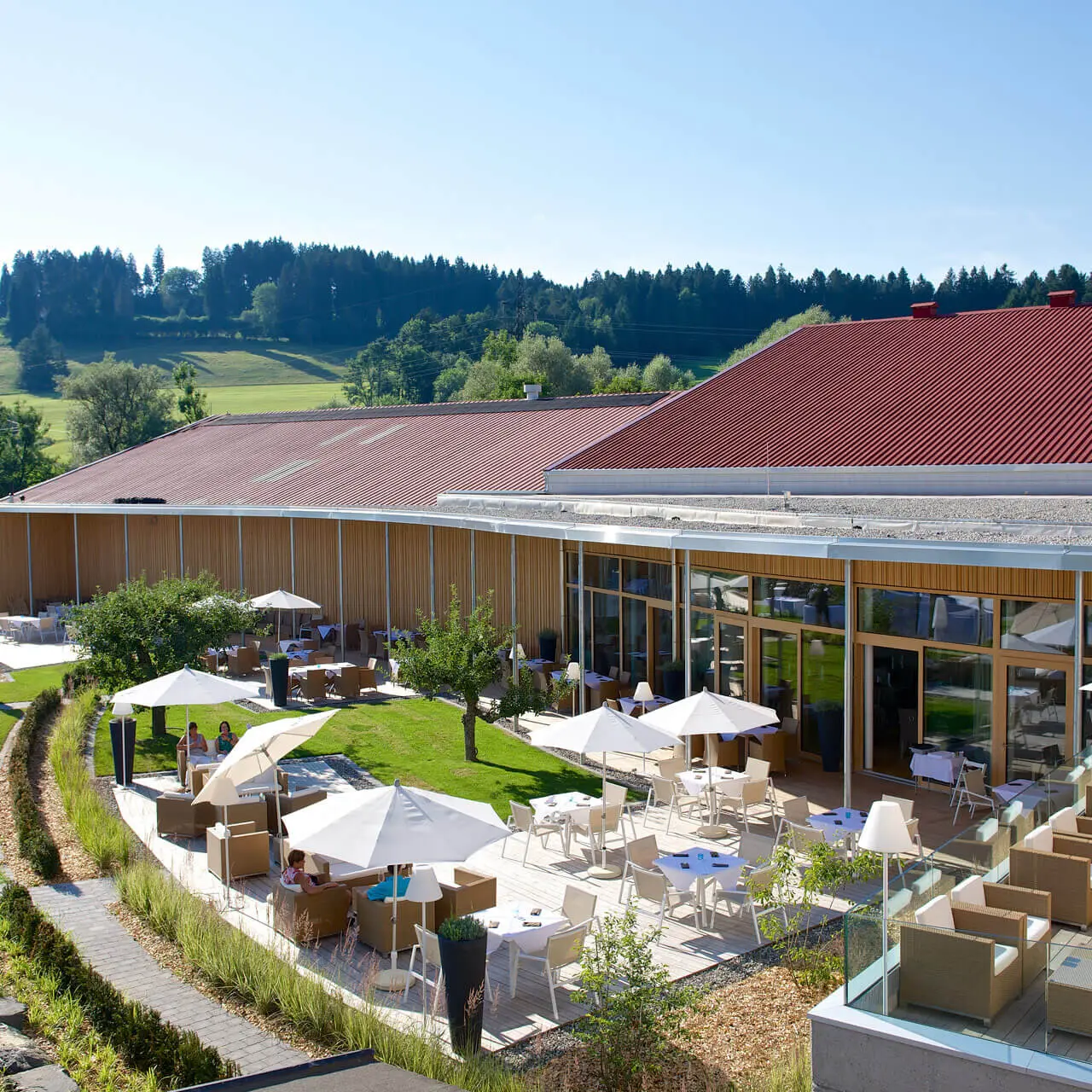 Sonnige Restaurantterrasse mit bequemen Sitzgelegenheiten und Blick ins Grüne im Tannenhof Sport & SPA.