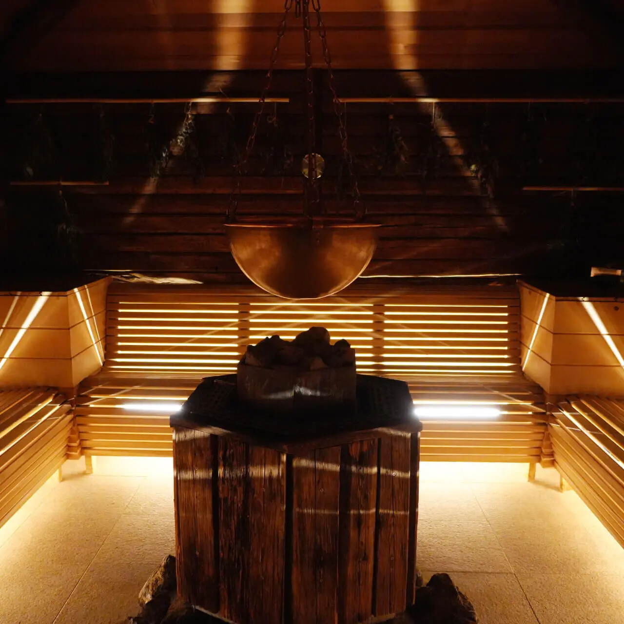 Traditionelle Holzsauna mit Kupferkessel und Kräutern im Wellnessbereich des Tannenhof Sport & SPA.