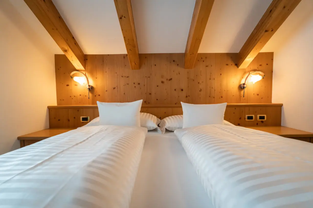 The Cacciatora Wellness & Beauty Hotel in Alba di Canazei – Doppelzimmer mit Holzbalken | Wellnesshotel Dolomiten