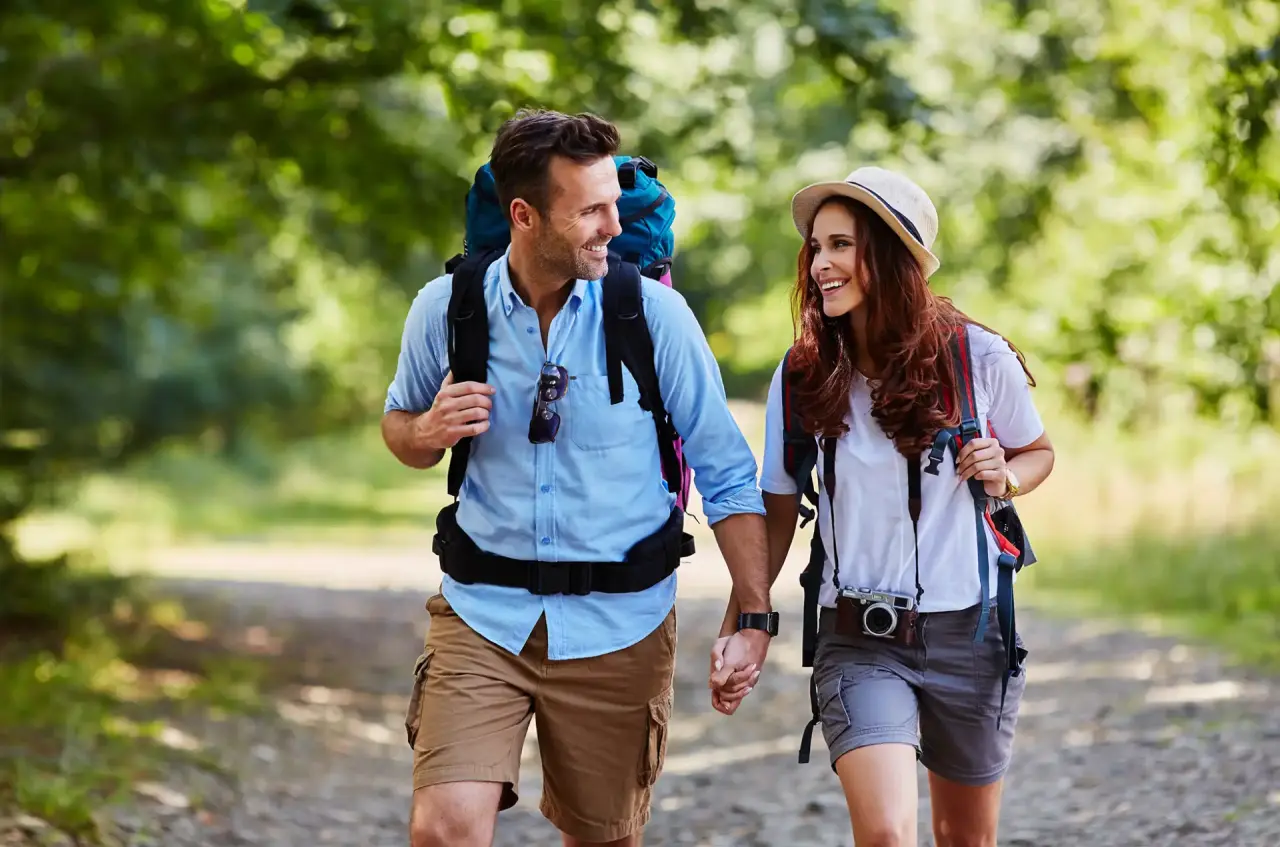 Wanderndes Paar auf einem Waldweg, das die Natur rund um das Golf- & Alpin Wellness Resort Hotel Ludwig Royal genießt.