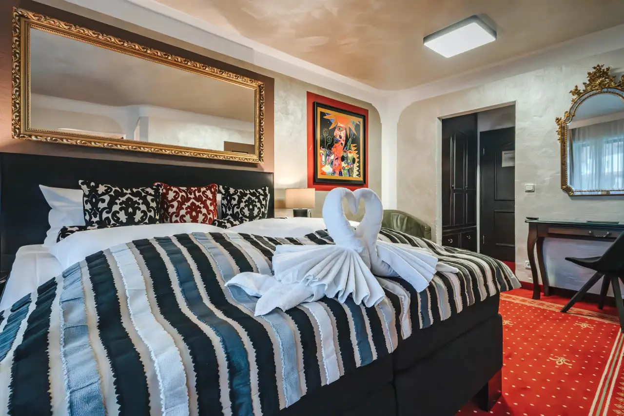 Gemütliches Doppelzimmer mit elegantem Bett und rotem Teppich im Golf- & Alpin Wellness Resort Hotel Ludwig Royal.