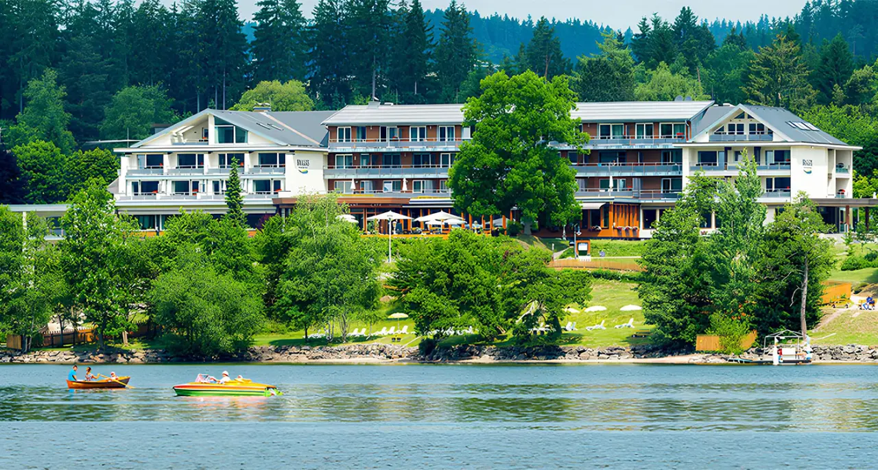 Brugger's Hotelpark am Titisee mit Blick auf den See und die umliegende Natur. Einladende Aussenansicht des Wellnesshotels.