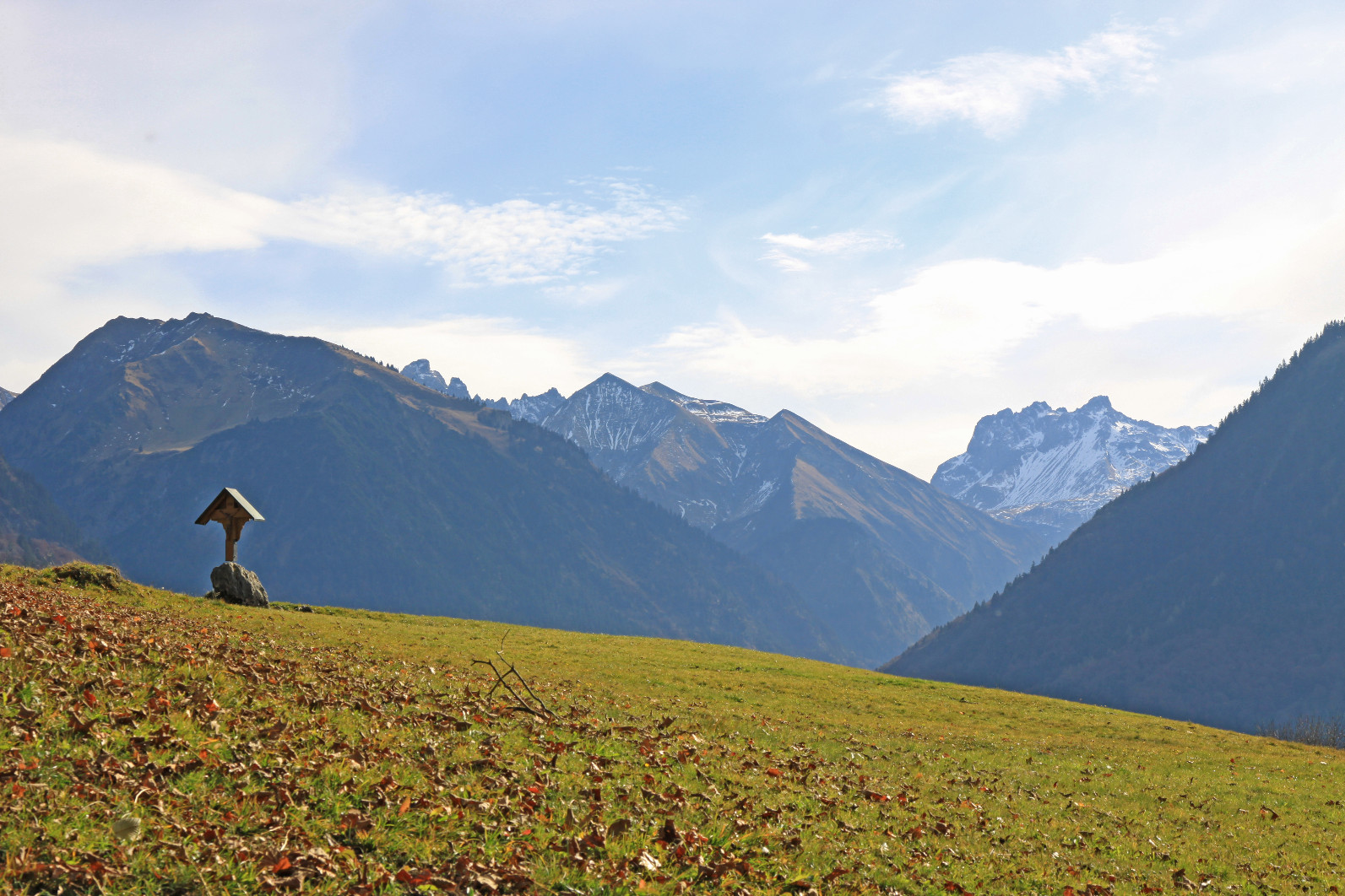 Hotel Alpenstüble in Mittelberg – Bergpanorama mit Holzkreuz und Herbstwiese | Wellnesshotel Allgäu