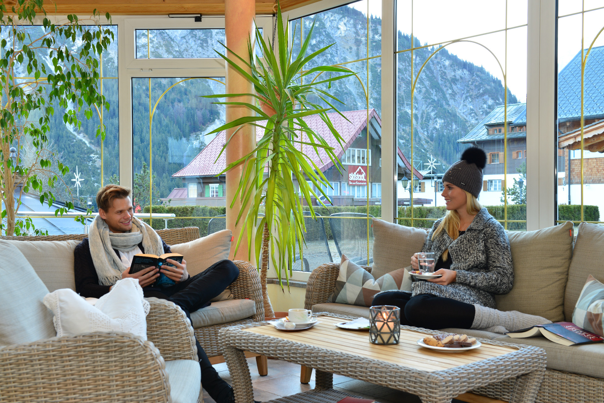 Hotel Alpenstüble in Mittelberg – Entspannte Gäste in der hellen Hotellounge mit Bergblick | Wellnesshotel Alpen