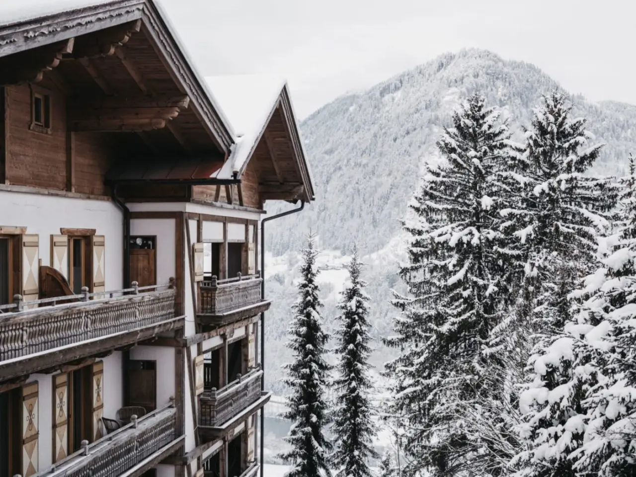 Traditionelles Hotel Oberforsthof im Winter mit verschneiten Balkonen und Alpenpanorama.