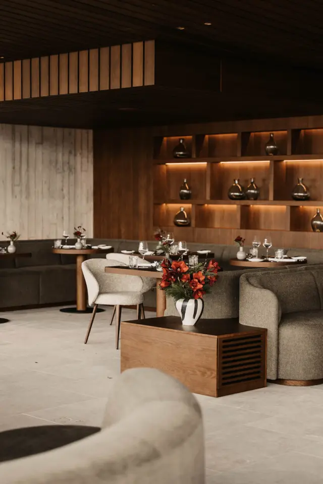 Modernes Restaurant im Hotel Oberforsthof mit stilvoller Holzvertäfelung, gemütlichen Sitzbereichen und elegant gedeckten Tischen.