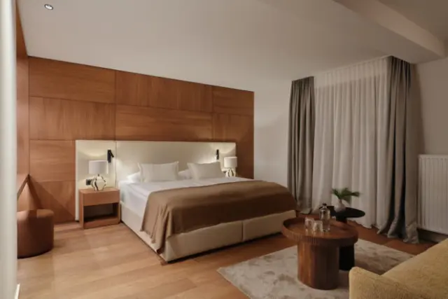 Modernes Doppelzimmer mit Holzwand, bequemen Bett und stilvoller Einrichtung im Hotel Oberforsthof
