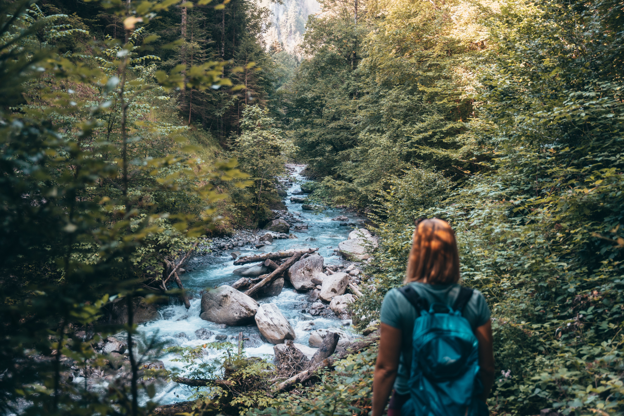 Alpinresort Schillerkopf in Bürserberg – Wanderin am Gebirgsbach im Wald | Wellnesshotel Vorarlberg