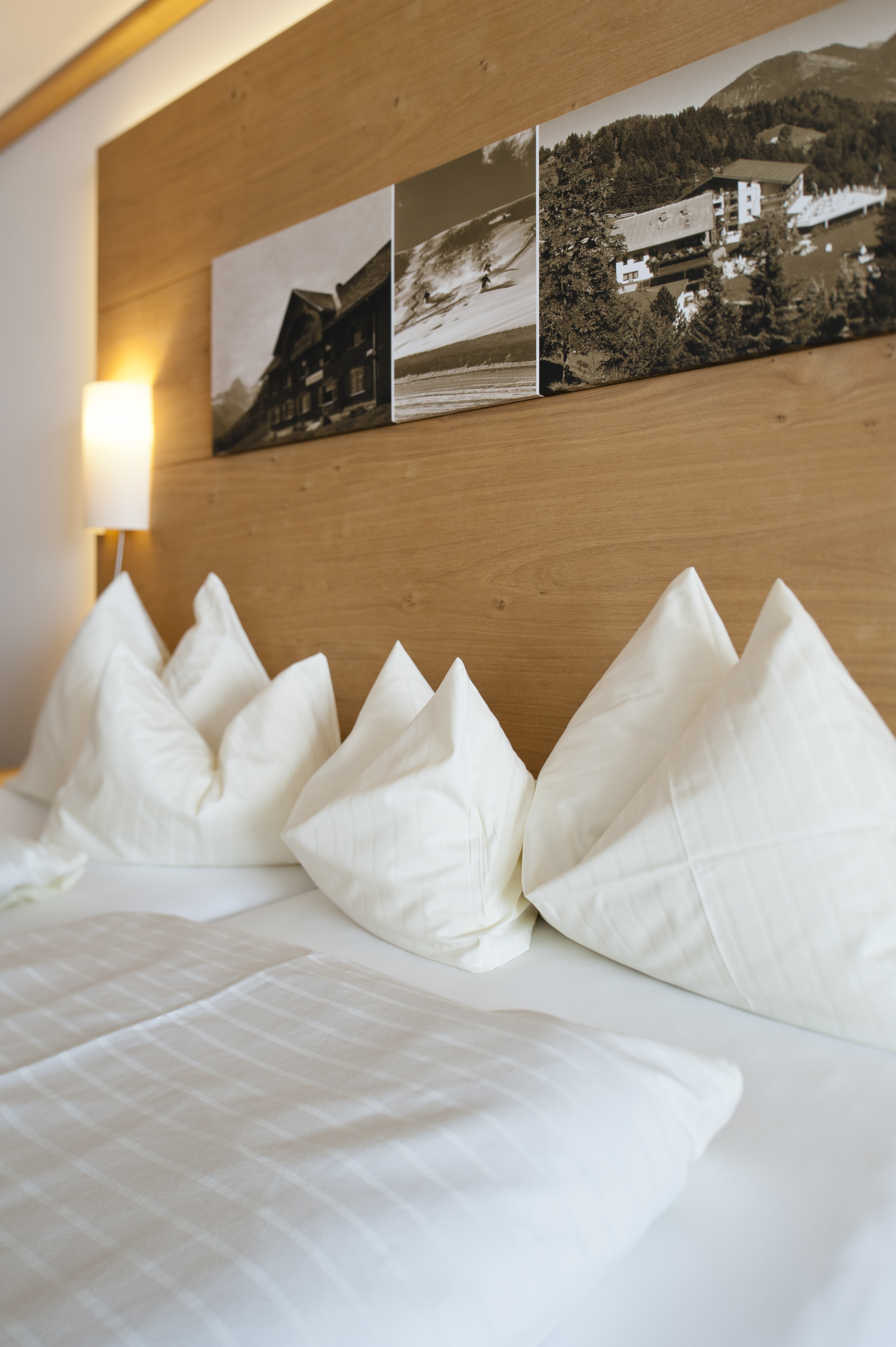 Alpinresort Schillerkopf in Bürserberg – Gemütliches Hotelzimmer mit Holzkopfteil und Bildern | Wellnesshotel Vorarlberg
