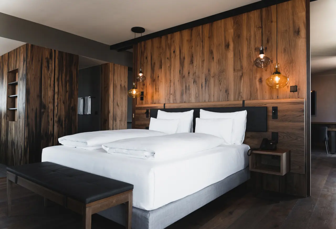 Modernes Doppelzimmer mit Holzwänden und stilvollen Lampen im Scheiblhofer The Resort.