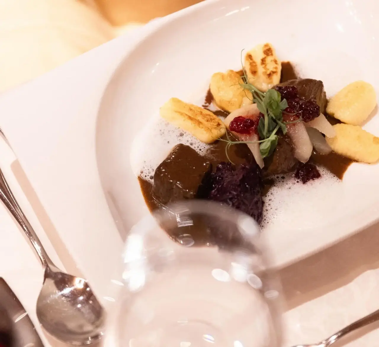 Exquisites Wildgericht mit Knödeln und Preiselbeeren im Restaurant des Vitalhotel Berghof.