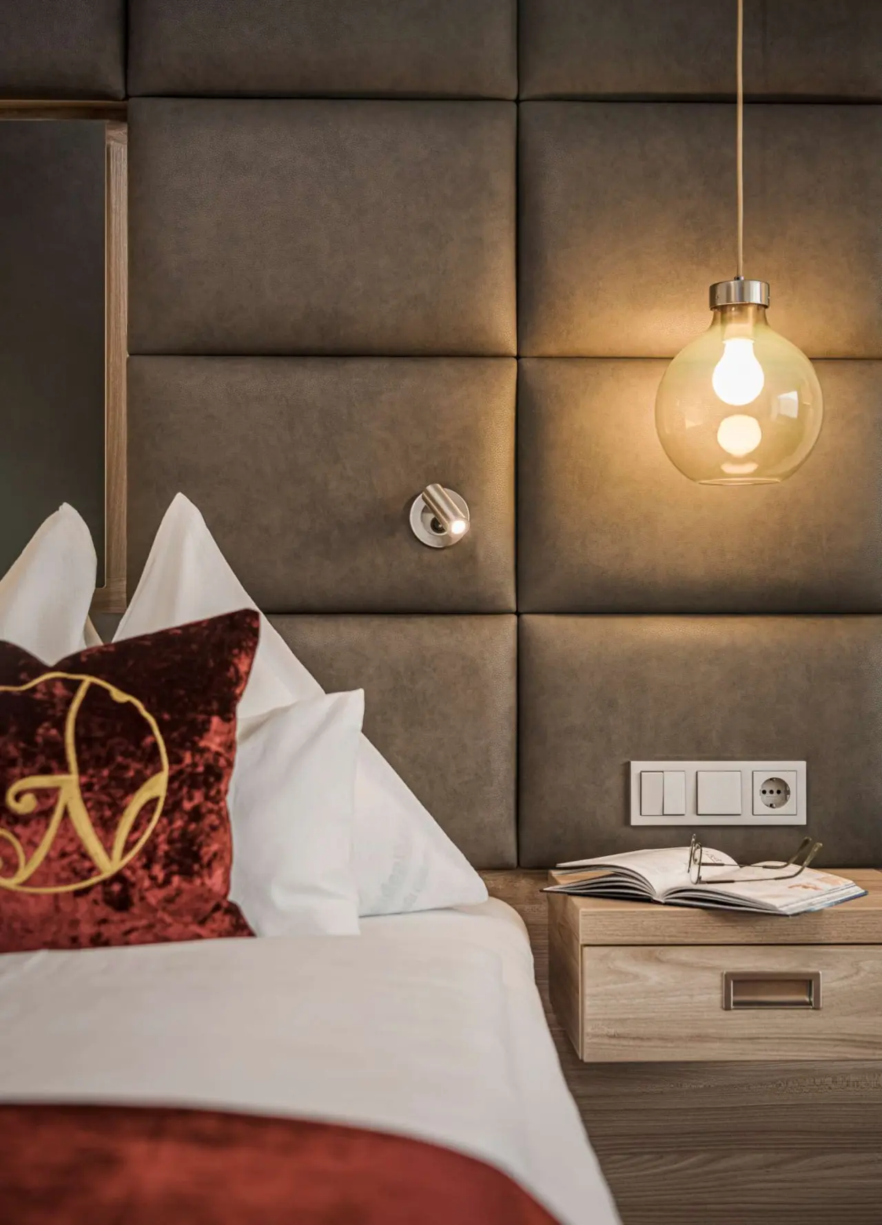 Gemütliches Hotelzimmer mit bequemen Betten und Nachttischlampe im Hotel Norica.