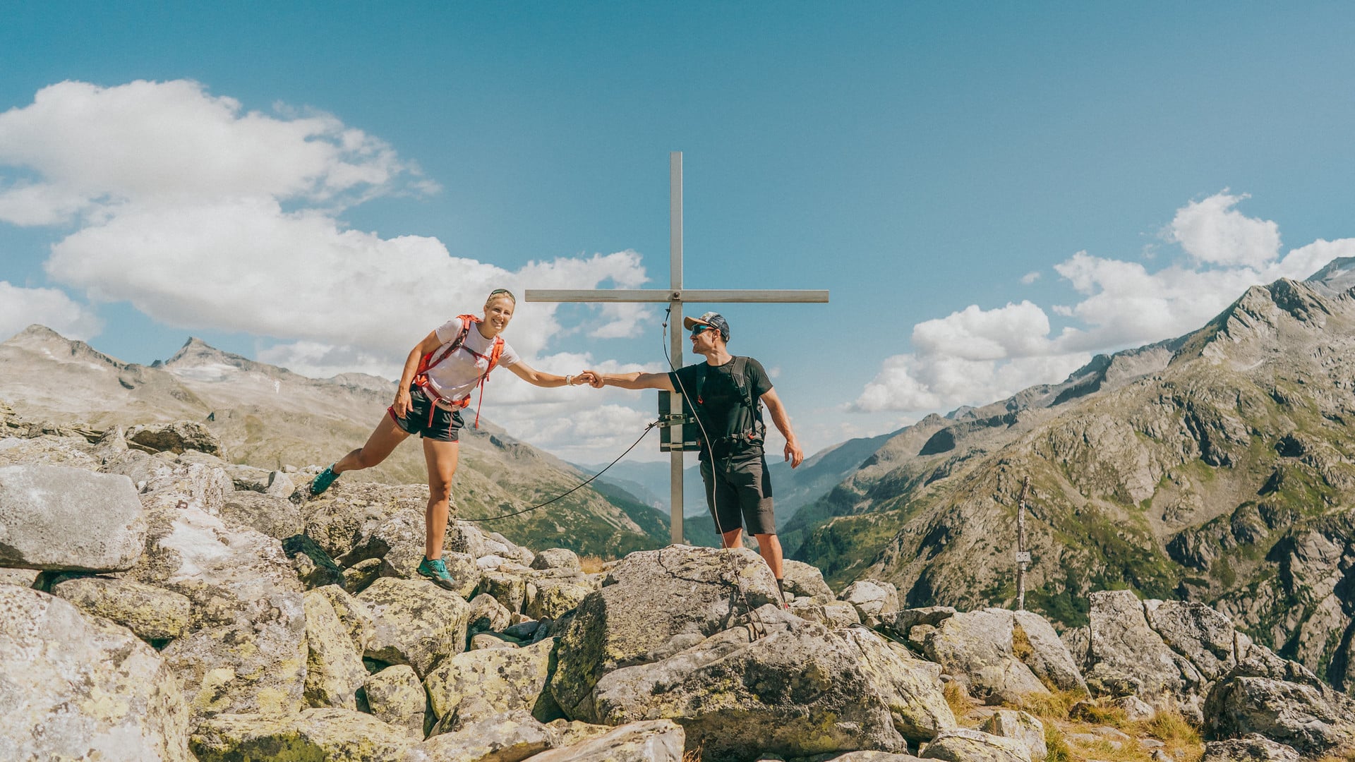 Wellnesshotel Eggerwirt in St. Michael – Wandererpaar am Gipfelkreuz mit Bergpanorama | Wellnesshotel Lungau