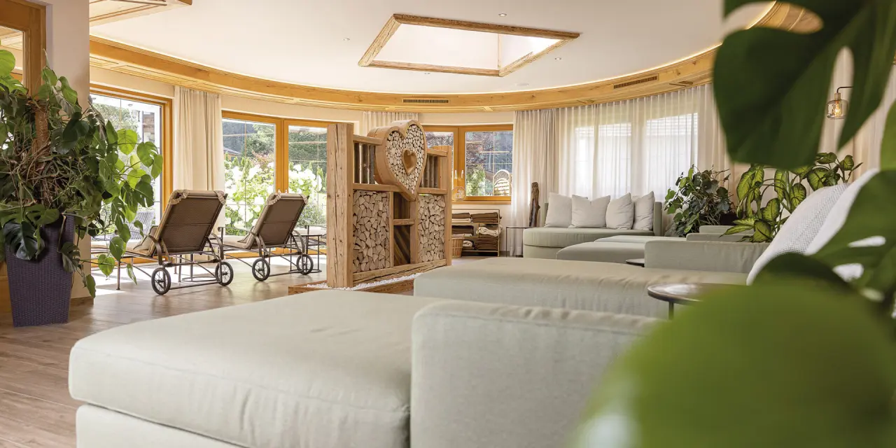 Gemütlicher Ruheraum mit bequemen Liegen, Pflanzen und Holzelementen im Aktiv- & Vitalhotel Bergcristall.